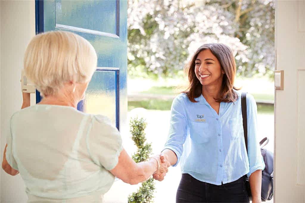 Tapi female representative greets an elderly woman